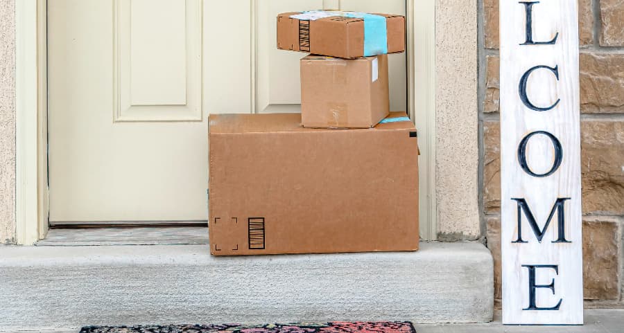 Packages on the doorstep of a home with a welcome sign in Logan